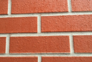 Se muestra un producto similar a la pintura que se aplicó menos de dos años antes de haber tomado la fotografía. El color es de un solo tono y la superficie está ampollada. El mortero también tiene un producto similar a la pintura. Estos productos no son tintes especiales para mampostería.