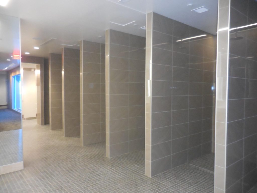 Las duchas del vestidor están listas para recibir un uso continuo con HYDRO BAN de LATICRETE, mortero 4-XLT y lechada SPECTRALOCK PRO en los pisos con lechada PERMACOLOR Select en las paredes Fotografía de Neuse Tile Service