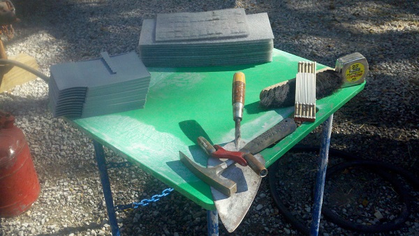 Se muestran una tabla para mezcla y más herramientas del negocio de la albañilería.