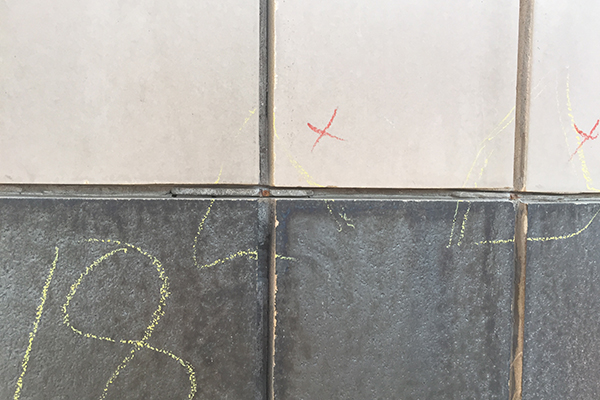 Esta fotografía muestra un componente de anclaje que tiene una cubierta de menos de los 5/8 de pulgada necesarios para el frente exterior. Los amarres están empezando a corroerse.