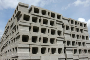 Stacked concrete building blocks shot against a blue sky.