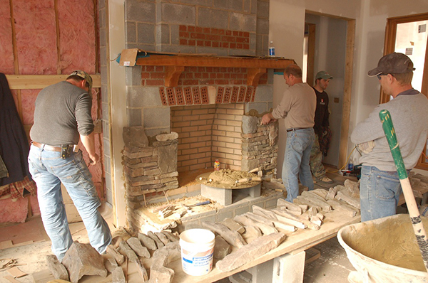En la imagen se muestra la instalación de las coronas de chimenea con unidades de enchapado de mampostería adheridas. Crédito: Imagen cortesía de Keiger Masonry 
